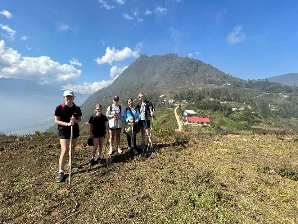 Group trekking through the golden hillside terrain near Hang Da village on the 2D1N Sapa trek