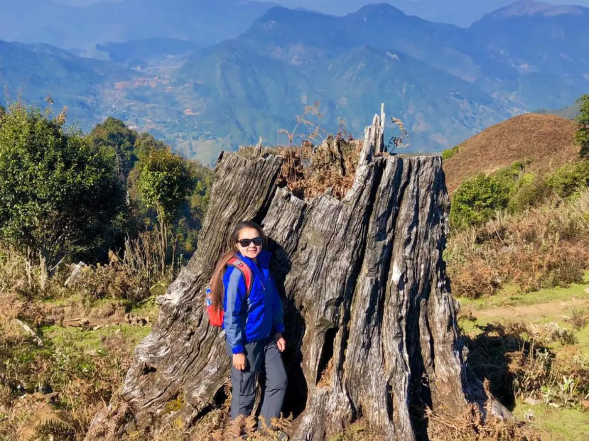 Solo trekker standing on high mountain ridge above valley