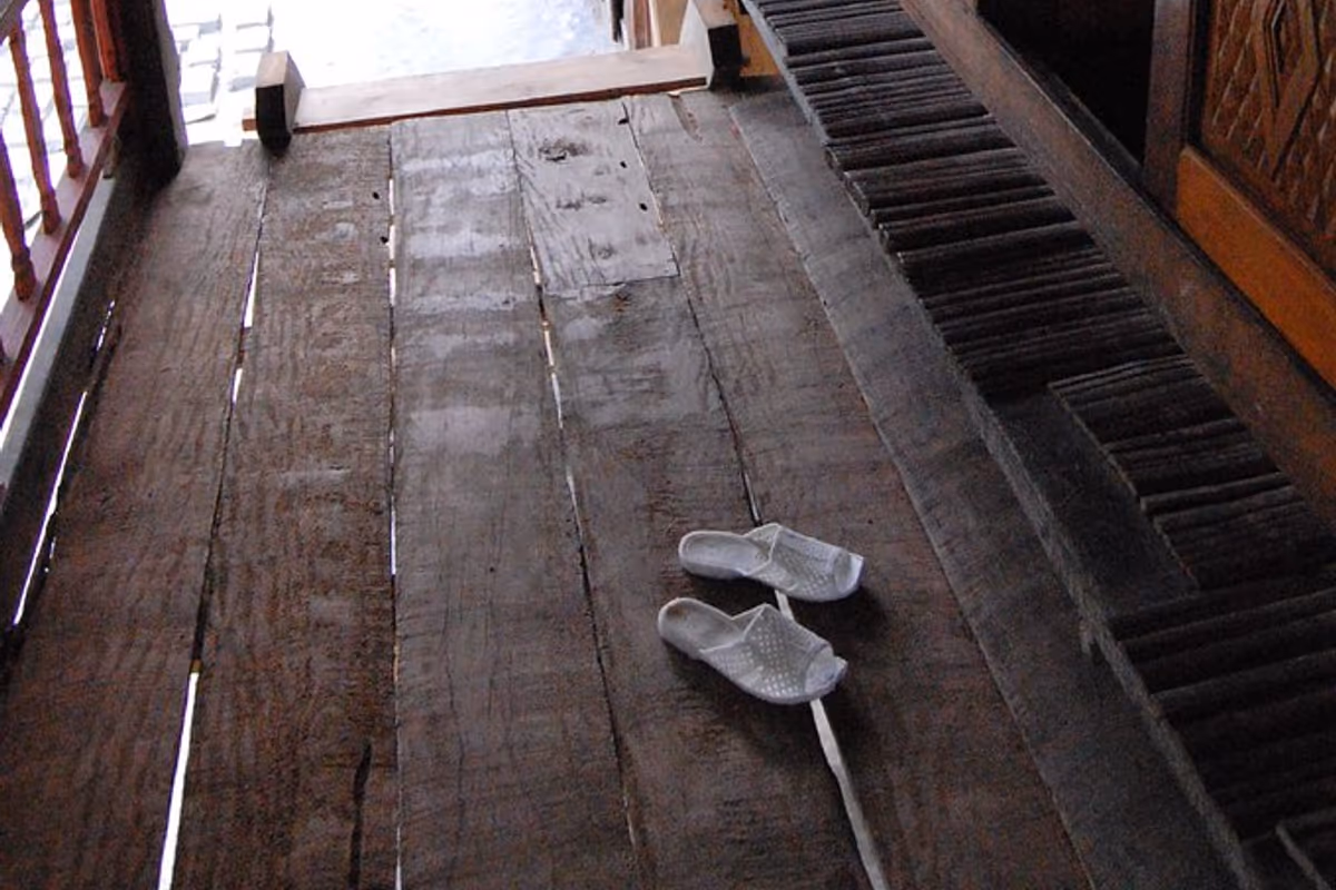 Bamboo-slat floor and sandals on the veranda of a Tay stilt house in Ban Ho village, Sapa