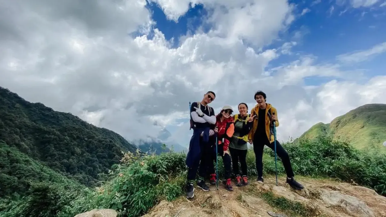 Trekkers on a grassy ridge in Hoang Lien National Park on the Fansipan one-day trek, Sapa