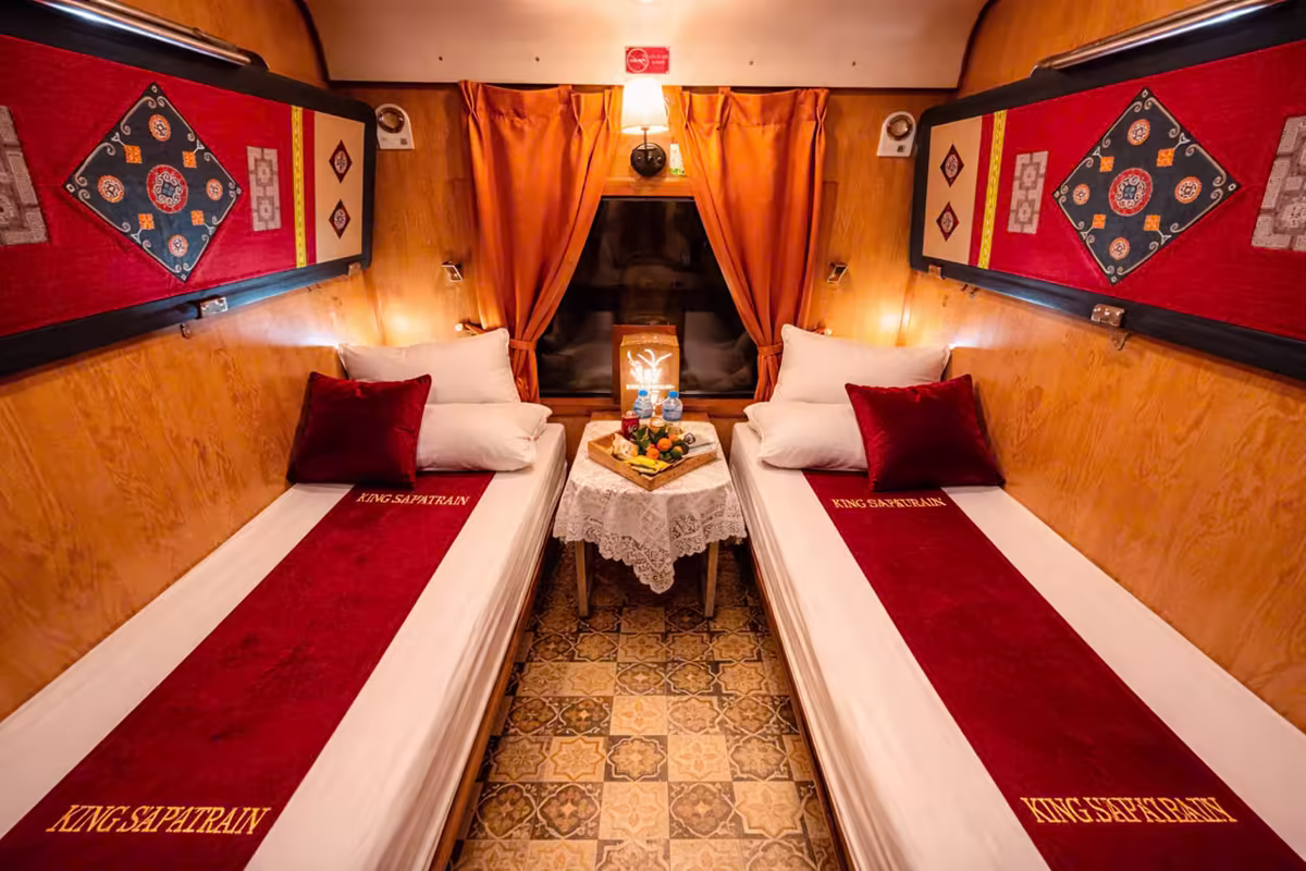 King Sapa Train Private VIP Twin cabin with two single beds, embroidered wall panels and welcome tray