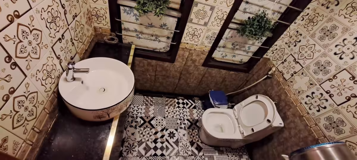 King Sapa Train shared washroom with patterned ceramic tiles, round washbasin and Western toilet