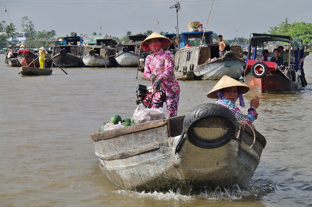 Boats trading fruit and vegetables at a Mekong Delta floating market, a symbol of Vietnam's low prices
