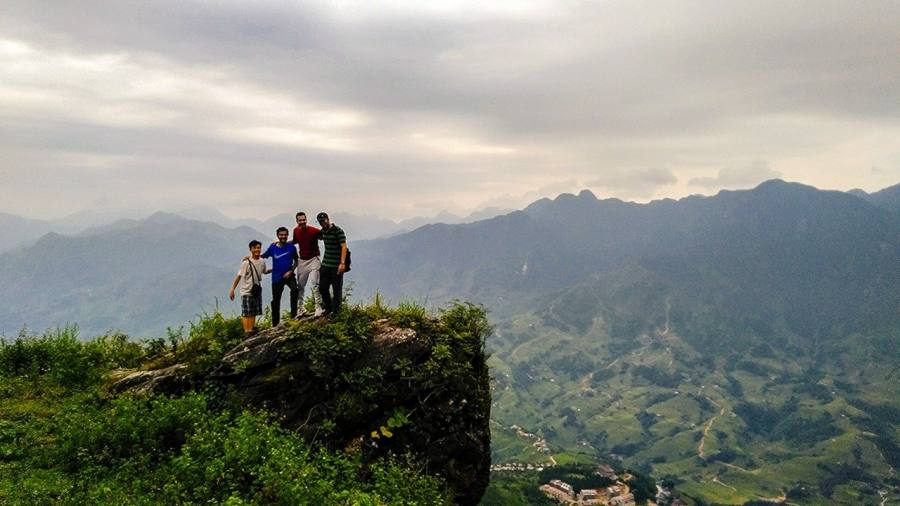 Trekkers on the rocky summit — panoramic views across the Hoang Lien Son range