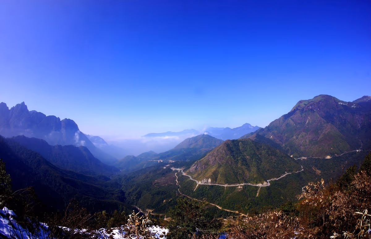 View from the top of O Quy Ho Pass at Heaven Gate, with National Road 4D winding down through the Hoang Lien Son mountains toward Lai Chau