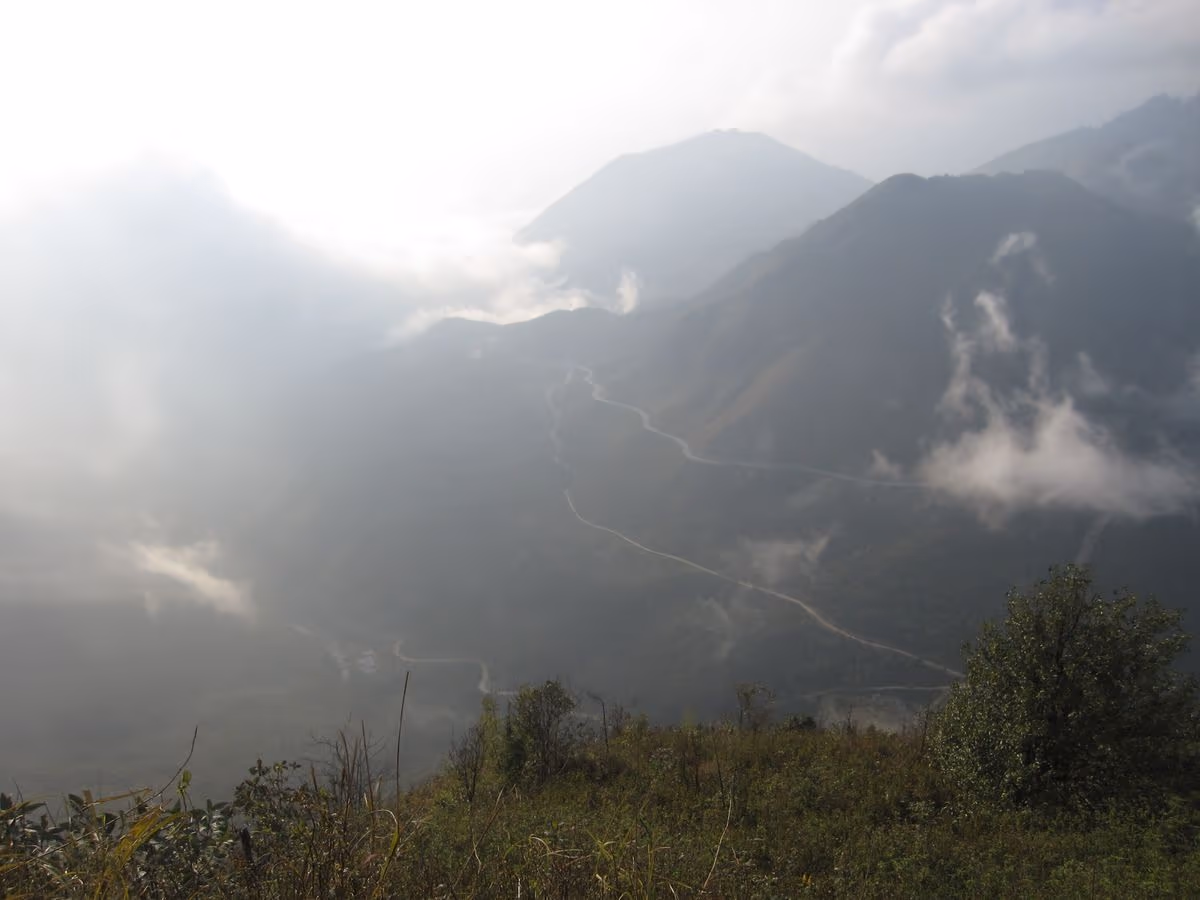 Switchbacks of O Quy Ho Pass seen from above with cloud drifting across the valley