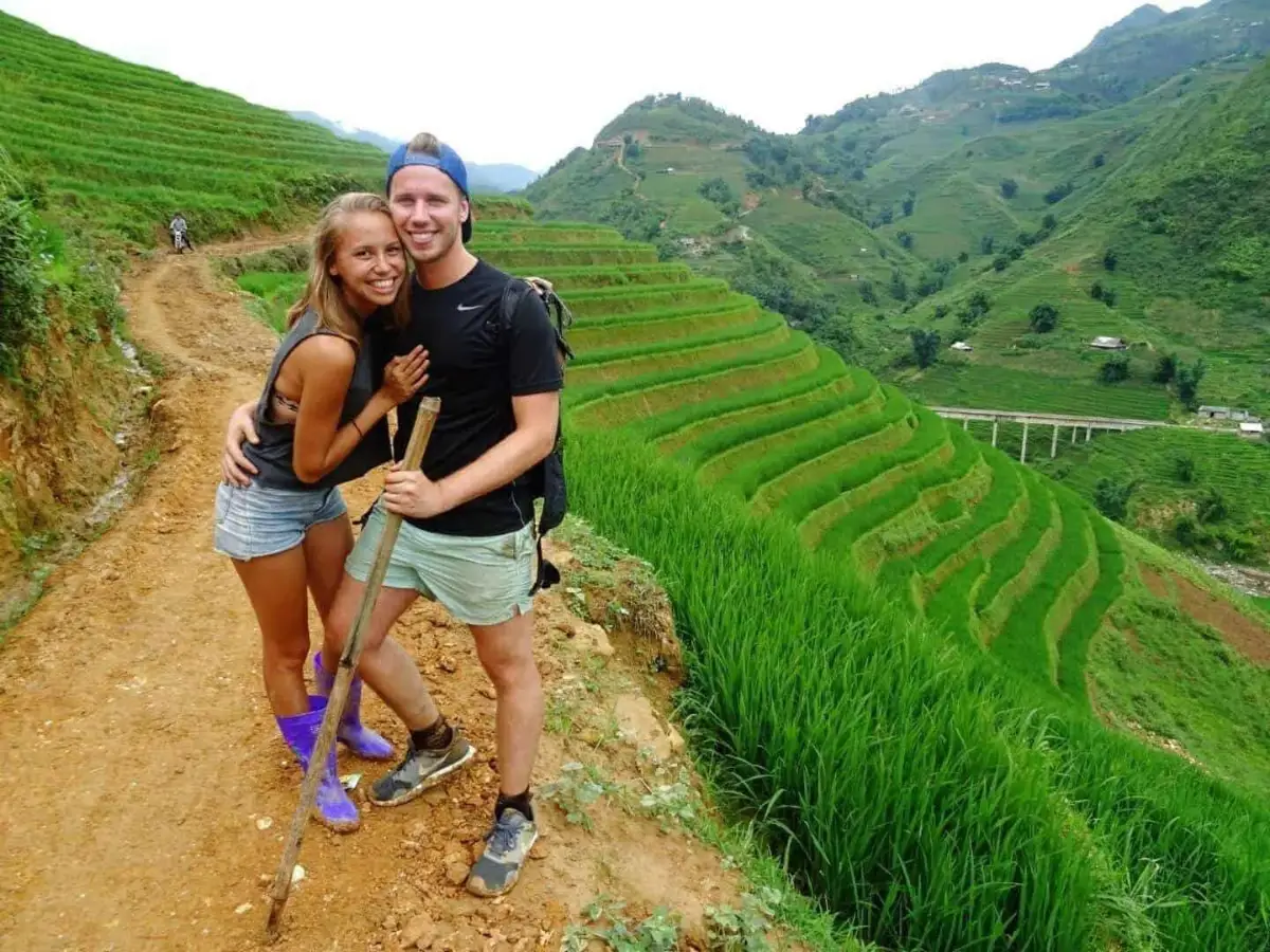Trekking through Sapa rice terraced fields with trekking poles in Muong Hoa Valley