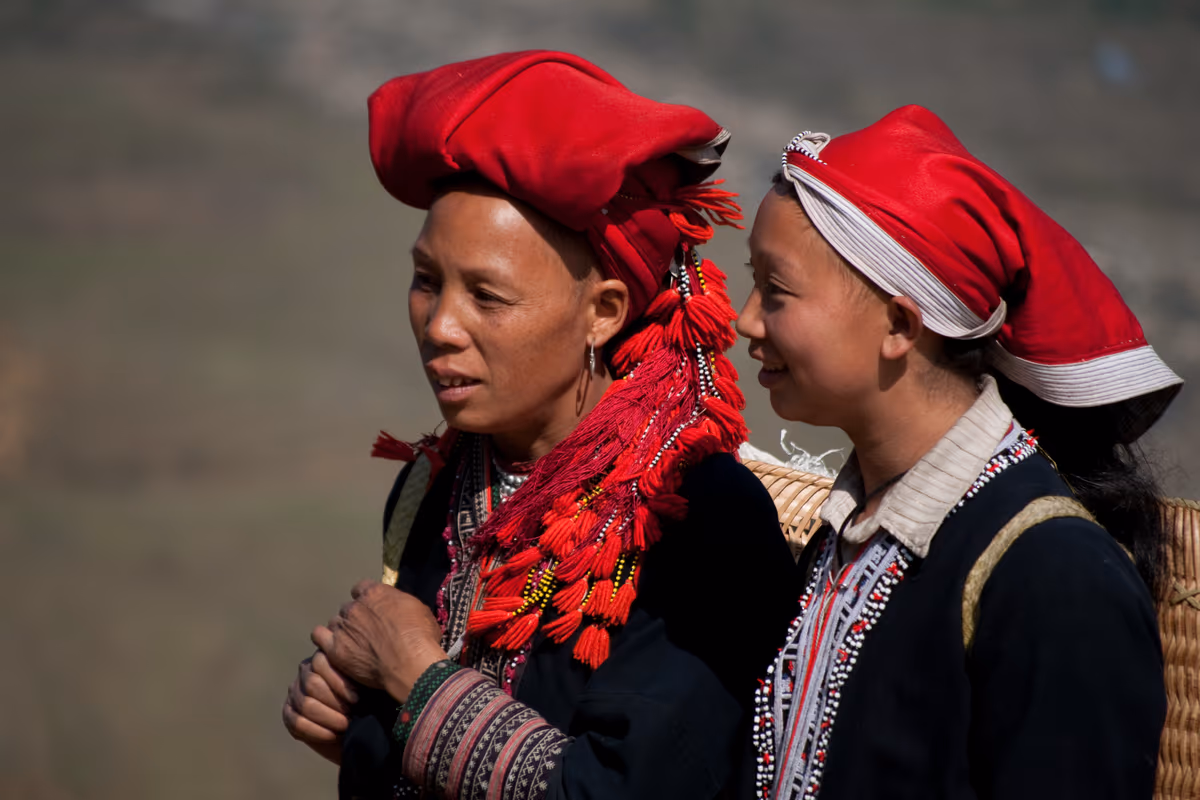 Two Red Dao women in traditional red headdresses and embroidered clothing, Sapa area, Vietnam