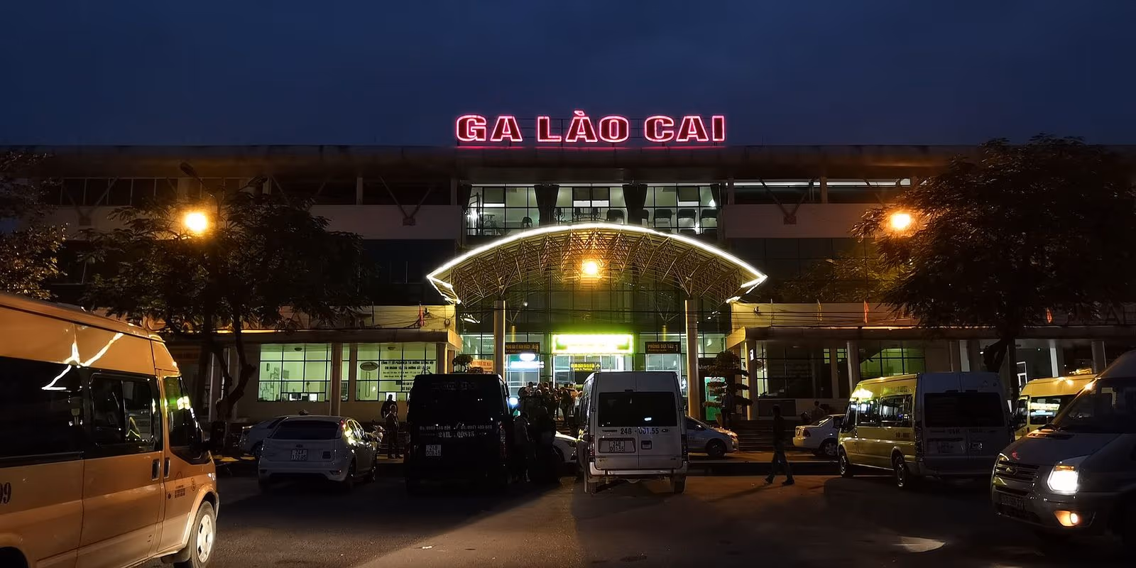 Lao Cai railway station with its red GA LAO CAI sign and minivans waiting outside