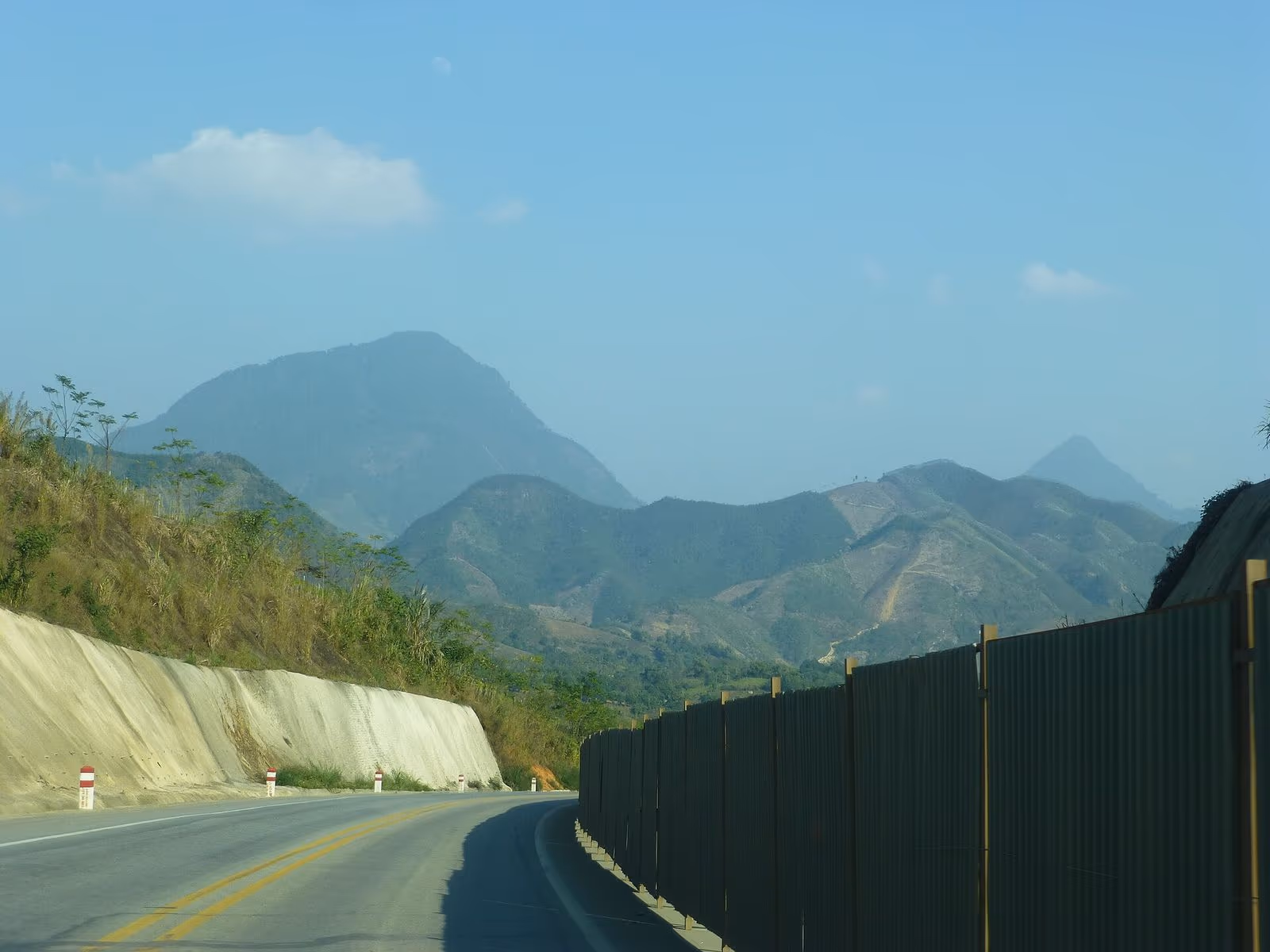 A curving two-lane stretch of the Hanoi to Lao Cai Expressway with hills ahead