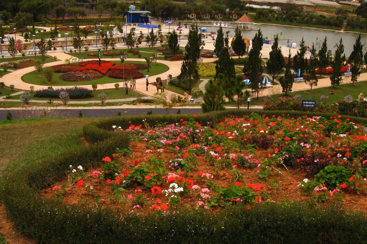 Flower beds, paths, pine trees and a lake seen from a hillside in the Da Lat flower garden